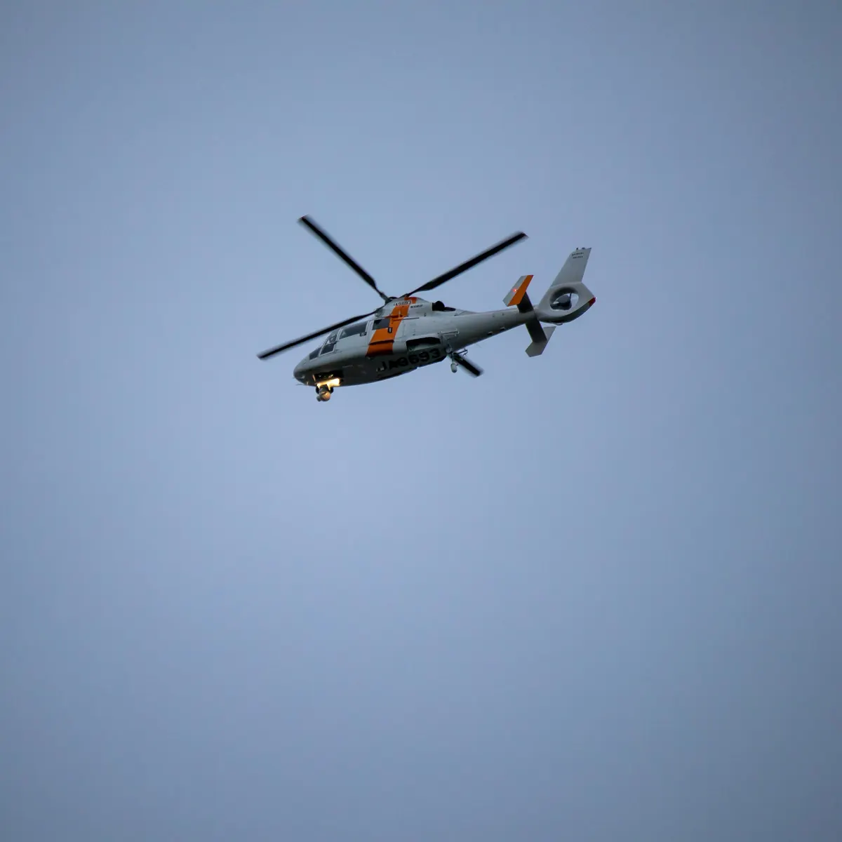 Twin-engine helicopter flying against a clear sky
