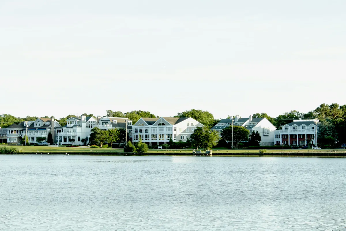Row of shingled houses along a calm bay